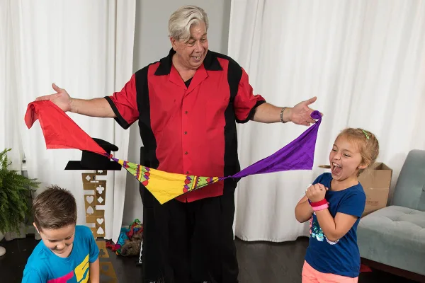 A young volunteer helps with a magic trick